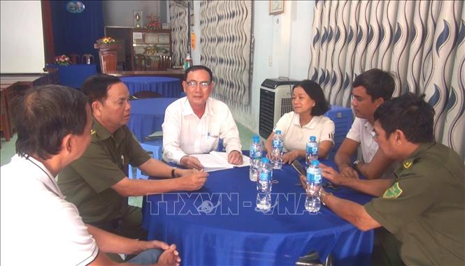 Ông Nguyễn Hoài Trung, Bí thư Chi bộ, Trưởng khu phố 3, xã Đức Hòa, tỉnh Tây Ninh đang trao đổi cùng tổ an ninh tự quản. Ảnh: Thanh Bình - TTXVN