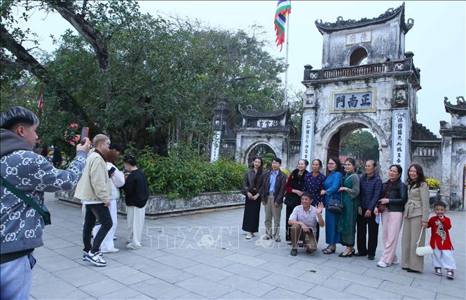 Người dân, du khách lưu giữ khoảnh khắc đến với Khu di tích lịch sử, văn hóa đặc biệt đền Trần - Chùa Tháp đầu Xuân năm mới. Ảnh: Công Luật - TTXVN
