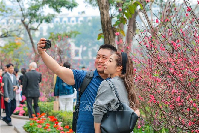 Cùng nhau lưu giữ kỷ niệm du Xuân trong chiều mùng 3 Tết Bính Ngọ. Ảnh: Hoàng Hiếu - TTXVN