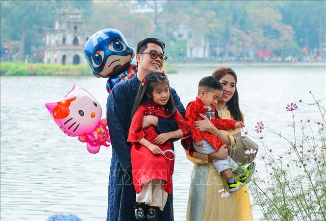 Một gia đình lưu giữ kỷ niệm tại hồ Hoàn Kiếm chiều mùng 3 Tết. Ảnh: Hoàng Hiếu - TTXVN