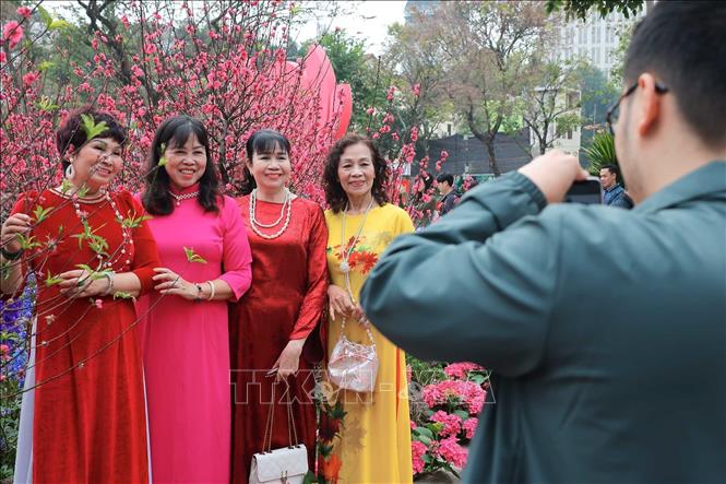 Quanh Hồ Gươm, hình ảnh những tà áo dài truyền thống thướt tha hòa cùng nụ cười rạng rỡ của người dân đã tạo nên bức tranh xuân duyên dáng và đậm đà bản sắc. Ảnh: Hoàng Hiếu - TTXVN