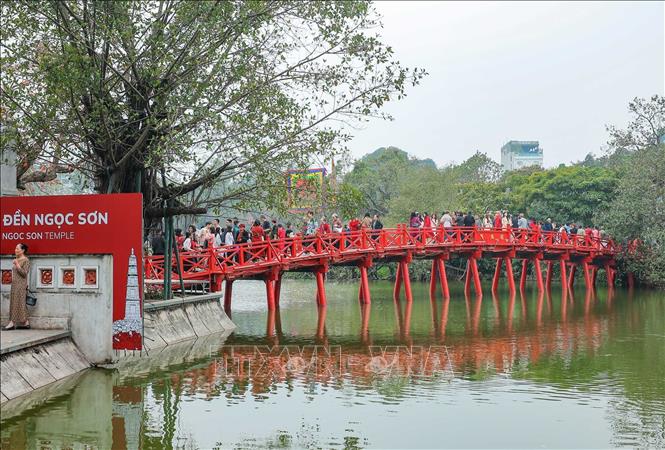 Nhiều người dân và du khách cùng đi du Xuân, tham quan đền Ngọc Sơn chiều mùng 3 Tết. Ảnh: Hoàng Hiếu - TTXVN