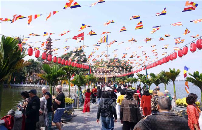 Đông đảo du khách trong nước và quốc tế đến tham quan và đi lễ tại Chùa Trấn Quốc trong ngày Mùng 4 Tết. Ảnh: Phạm Kiên - TTXVN