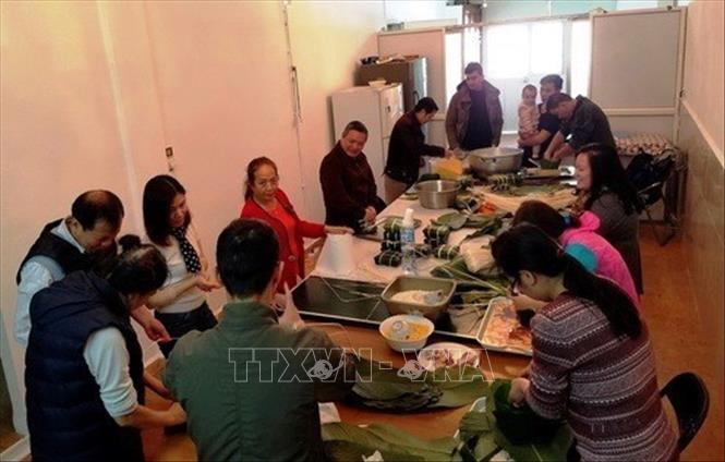 Cộng đồng người Việt Nam tại Algeria gói và nấu bánh chưng đón Tết. Ảnh: Tấn Đạt - TTXVN  