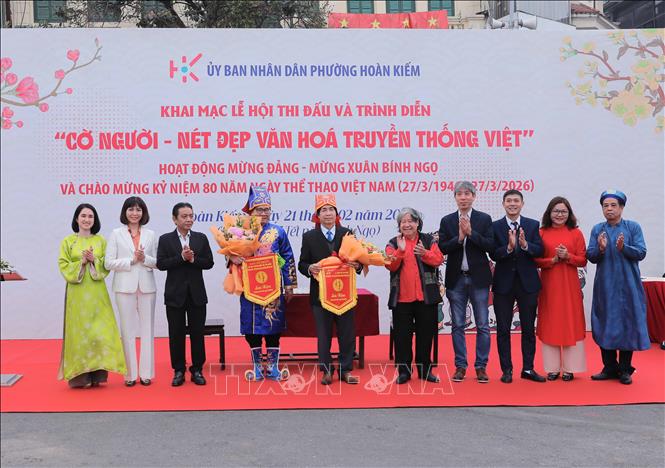 Thứ trưởng Bộ VHTTDL Hoàng Đạo Cương tặng hoa chúc mừng hai kỳ thủ. Ảnh: Phan Phương – TTXVN