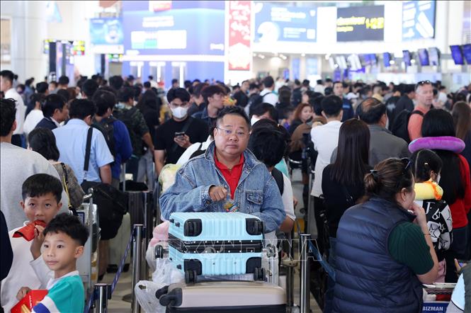 Anh Bùi Anh Tuấn (Tp Hồ Chí Minh) với khuôn mặt mệt mỏi chờ đợi làm thủ tục tại sảnh nội địa sân bay Nội Bài chiều mùng 5 Tết để trở về nhà. Ảnh: Quốc Khánh - TTXVN