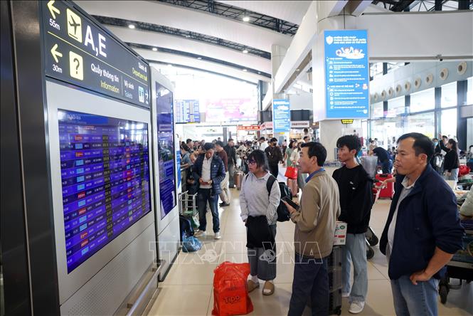 Hành khách tìm kiếm chuyến bay trên bảng điện tử tại sảnh nội địa sân bay Nội Bài, chiều mùng 5 Tết. Ảnh: Quốc Khánh - TTXVN