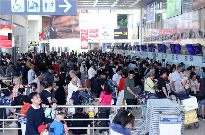 Khu vực sảnh nội địa sân bay Nội Bài chật kín người với hành lý lỉnh kỉnh, chờ đợi làm thủ tục chiều mùng 5 Tết. Ảnh: Quốc Khánh - TTXVN