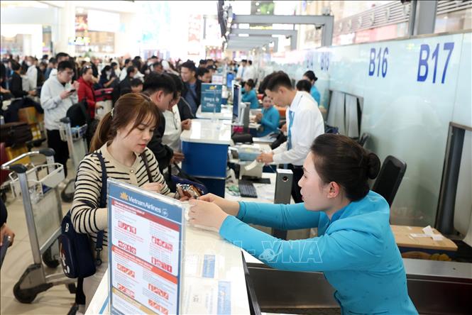 Người dân làm thủ tục check-in tại khu vực của Vietnam Airlines, sảnh nội địa sân bay Nội Bài, chiều 5 Tết. Ảnh: Quốc Khánh - TTXVN