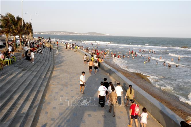 Bãi biển Thương Chánh đông nghịt du khách tắm biển vào chiều mùng 5 Tết Nguyên đán Bính Ngọ. Ảnh: Nguyễn Thanh - TTXVN