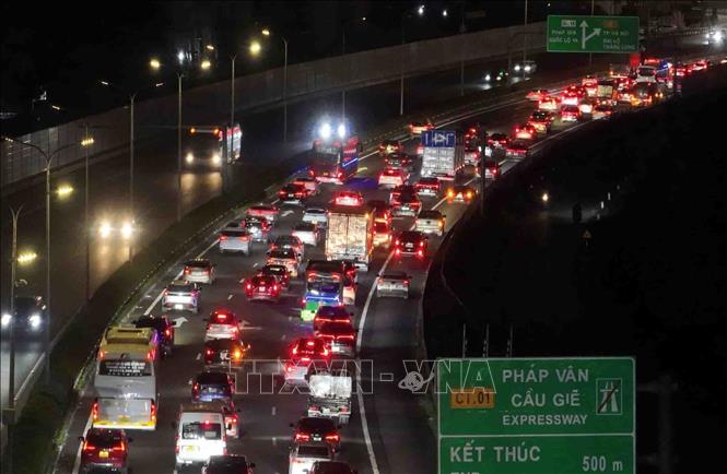 Các phương tiện nối đuôi nhau di chuyển khó khăn đoạn kết thúc cao tốc Pháp Vân - Cầu Giẽ hướng vào trung tâm Thủ đô trong tối 21/2 (ảnh chụp lúc 22h). Ảnh: Phạm Kiên - TTXVN