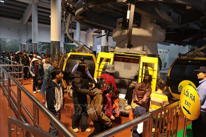 Du khách xếp hàng để đi cáp treo lên động Hương Tích. Ảnh: Trần Việt - TTXVN