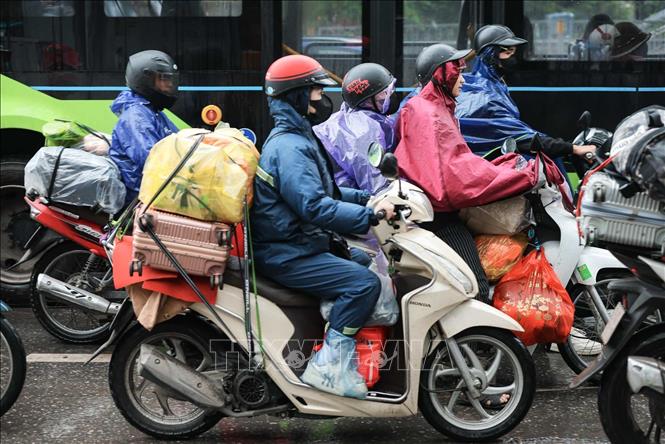 Người dân với đồ đạc được chằng buộc cẩn thận quay trở lại Thủ đô. Ảnh: Hoàng Hiếu - TTXVN