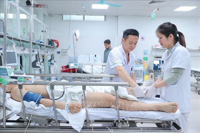 Điều dưỡng chăm sóc cho bệnh nhân đến cấp cứu tại bệnh viện Việt Đức dịp Tết. Ảnh: Minh Quyết - TTXVN