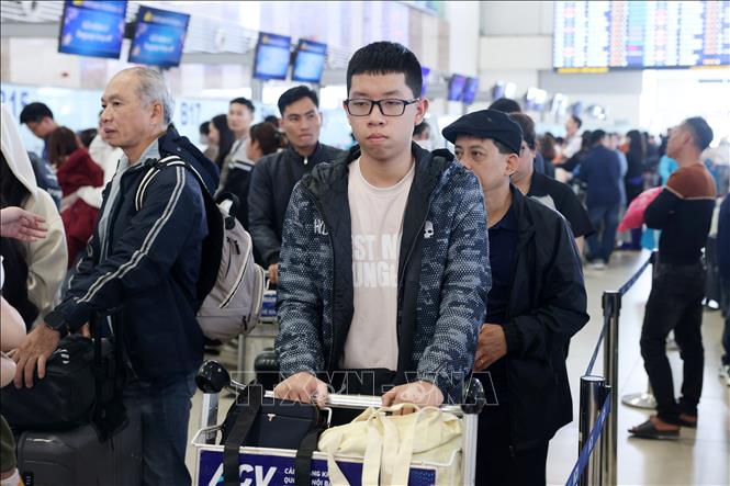 Hành khách xếp hàng làm thủ tục tại sảnh nội địa sân bay Nội Bài, chiều 22/2. Ảnh: Quốc Khánh - TTXVN