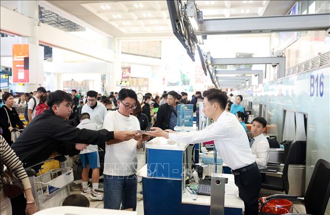 Hành khách làm thủ tục tại sảnh nội địa sân bay Nội Bài trong ngày cuối nghỉ Tết Bính Ngọ 22/2. Ảnh: Quốc Khánh - TTXVN