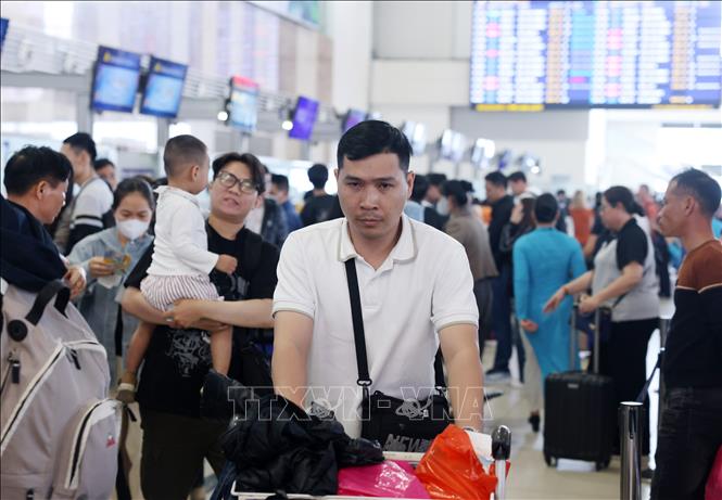 Hành khách xếp hàng làm thủ tục tại sảnh nội địa sân bay Nội Bài, chiều 22/2. Ảnh: Quốc Khánh - TTXVN