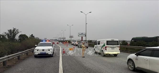 Đội CSGT đường bộ cao tốc số 3 (Cục CSGT) tổ chức phân luồng cho các phương tiện đi ngược chiều (theo hướng dẫn của lực lượng CSGT) từ Km216 đến Km211 nhằm tạo điều kiện cho phương tiện lưu thông thuận lợi về Hà Nội. Ảnh: TTXVN