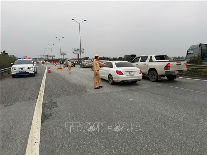 Đội CSGT đường bộ cao tốc số 3 (Cục CSGT) tổ chức phân luồng cho các phương tiện đi ngược chiều (theo hướng dẫn của lực lượng CSGT) từ Km216 đến Km211 nhằm tạo điều kiện cho phương tiện lưu thông thuận lợi về Hà Nội. Ảnh: TTXVN