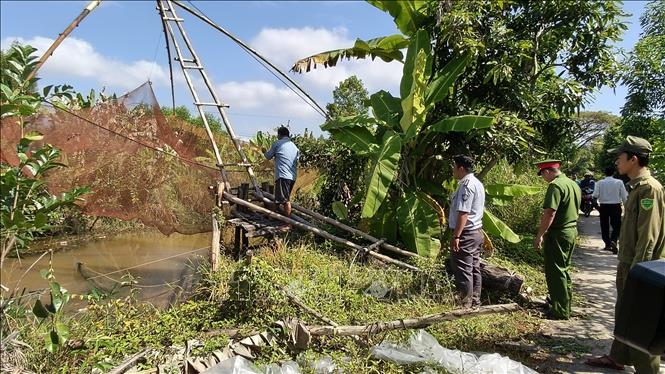 Lực lượng chức năng xã Nguyễn Phích, tỉnh Cà Mau, vận động hộ dân tháo dỡ vó trên các tuyến kênh rạch để bảo vệ nguồn lợi thủy sản. Ảnh: Tuấn Kiệt – TTXVN