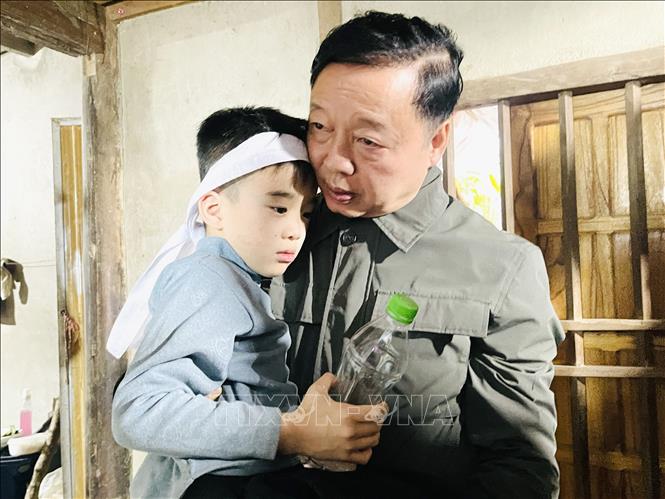 Phó Thủ tướng Trần Hồng Hà ân cần hỏi thăm sức khỏe cháu bé nhỏ nhất may mắn thoát nạn trong vụ chìm tàu. Ảnh: Đinh Thùy - TTXVN