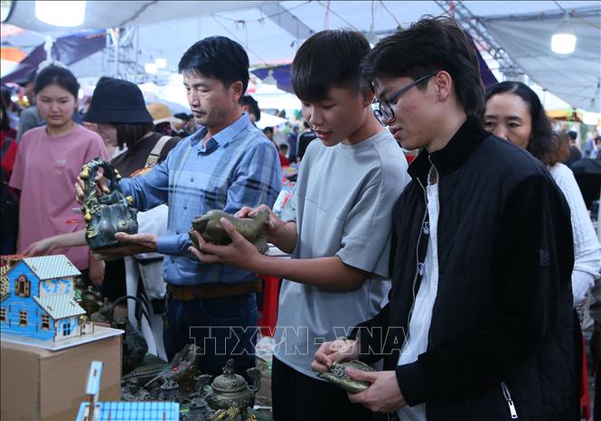 Gian hàng bày bán đồ cổ, giả cổ thu hút khách thăm quan, lựa chọn. Ảnh: Công Luật - TTXVN