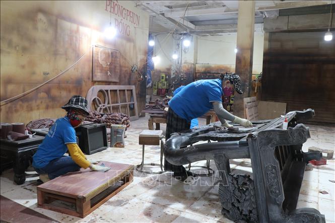 Workers sanding wood carefully to create shiny final piece of furniture. VNA Photo: Thanh Thương