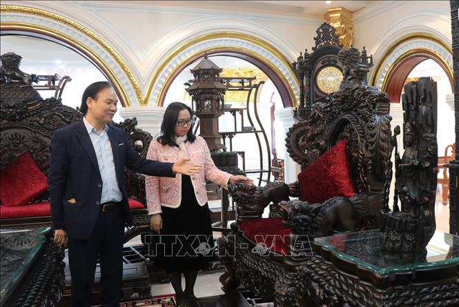Representatives of Nam Thang Fine Woodworking Company, Dong Nguyen ward, Bac Ninh province (on the left), introduce the family's wooden products. VNA Photo: Thanh Thương