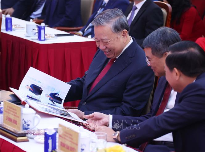 Tổng Bí thư Tô Lâm xem cuốn sách ảnh do phóng viên Ban biên tập Ảnh thực hiện. Ảnh: Văn Điệp - TTXVN
