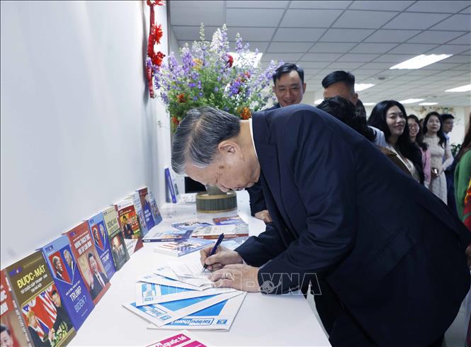 Tổng Bí thư Tô Lâm ký tặng lên ấn phẩm do Ban biên tập Tin thế giới thực hiện. Ảnh: Thống Nhất - TTXVN