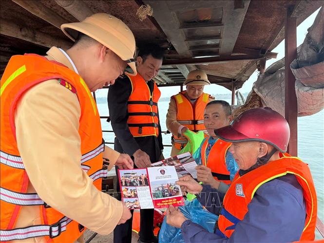 Lực lượng Cảnh sát đường thủy phối hợp với các đơn vị chức năng phát tờ rơi tuyên truyền, hướng dẫn người dân và chủ phương tiện chấp hành nghiêm Luật Giao thông đường thủy nội địa. Ảnh: TTXVN phát