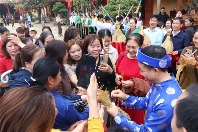 Người dân phấn khởi nhận lộc trong Tết Doi. Ảnh: Nguyễn Thảo - TTXVN