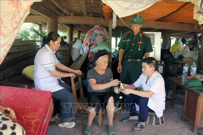 Sau khi thành lập Trạm y tế dã chiến, cán bộ y tế xã Mỹ Lý phối hợp cùng quân y Đồn Biên phòng Mỹ Lý tổ chức thăm khám, chữa bệnh cho người cao tuổi và những bệnh nhân không có điều kiện đến khám.  Ảnh: Văn Tý - TTXVN