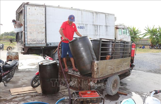 Nước ngọt được vận chuyển lên tàu cá trước khi ra khơi. Ảnh: Hữu Chí - TTXVN