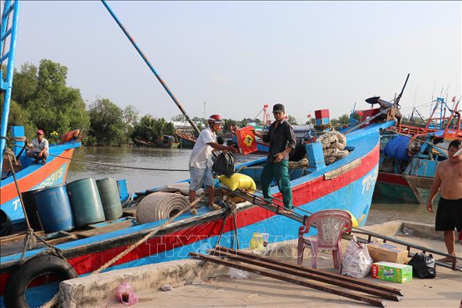 Các thuyền viên chuẩn bị hành lý cho chuyến ra khơi đầu năm. Ảnh: Hữu Chí - TTXVN