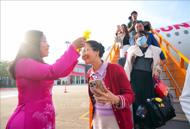 Phó Chủ tịch UBND thành phố Đà Nẵng Nguyễn Thị Anh Thi trao hoa chúc mừng các vị khách đầu tiên đến Đà Nẵng trên tàu bay Sun PhuQuoc Airways. Ảnh: TTXVN phát