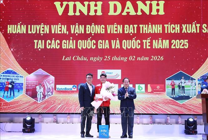 Phó Chủ tịch Thường trực UBND tỉnh Lai Châu Tống Thanh Hải tặng hoa chúc mừng VĐV Bùi Tuấn Tú, vận động viên đoạt Huy chương Bạc môn điền kinh tại Đại hội thể thao Châu Á. Ảnh: Quý Trung - TTXVN 