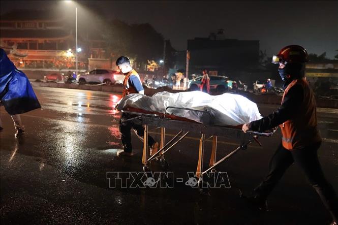 Lực lượng chức năng di chuyển nạn nhân ra khỏi hiện trường. Ảnh: Phạm Tuấn Anh - TTXVN