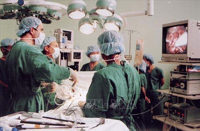 Nhiều kỹ thuật chuyên môn cao được thực hiện thành công tại nhiều bệnh viện trung ương như ghép tạng, nội soi, phẫu thuật bằng robot, chuyển giao một số kỹ thuật cho bệnh viện tuyến tỉnh, huyện...Trong ảnh: Các giáo sư, bác sĩ Viện trường Liege' (Vương quốc Bỉ) và các bác sĩ bệnh viện Nhân dân 115 (TP Hồ Chí Minh) đang thực hiện ca mổ nội soi thận từ người hiến. Đây là ca mổ nội soi ghép thận lần thứ 4 của Viện (2004). Ảnh: Thế Anh - TTXVN