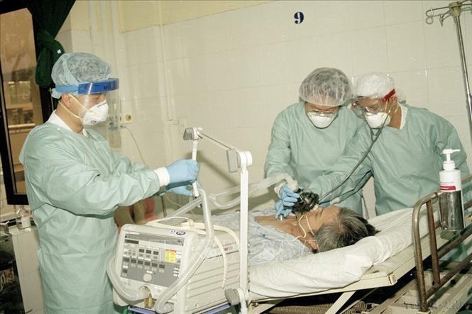 Không chỉ khống chế các dịch bệnh trong nước, Việt Nam là một trong những quốc gia đầu tiên khống chế thành công dịch SARS, cúm A/H5N1, cúm A/H1N1; ngăn chặn thành công không để một số dịch bệnh nguy hiểm mới nổi xâm nhập như cúm A/H7N9, Ebola, MERS-CoV, COVID-19... Trong ảnh: Các bác sĩ Viện Y học Lâm sàng các bệnh nhiệt đới Hà Nội điều trị cho bệnh nhân mắc SARS nặng (2003). Ảnh: Hữu Oai - TTXVN