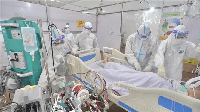 Hình ảnh các “chiến sĩ áo trắng” xả thân trong đại dịch COVID-19 để lại ấn tượng đẹp hơn bao giờ hết trong lòng nhân dân, thầm lặng vì sự an toàn của cộng đồng, cống hiến hết mình để viết nên bản hùng ca tự hào của ngành Y tế. Trong ảnh: Bác sỹ chăm sóc, điều trị bệnh nhân COVID-19 đa tầng tại Bệnh viện dã chiến Tân Bình (TP Hồ Chí Minh). Ảnh: TTXVN phát