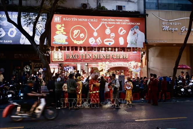 Người dân đội mưa chờ mua vàng ở cửa hàng Bảo Tín Minh Châu (Trần Nhân Tông, Hà Nội) từ sáng sớm. Ảnh: Trần Việt - TTXVN 