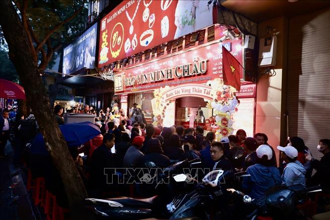 Người dân đội mưa chờ mua vàng ở cửa hàng Bảo Tín Minh Châu (Trần Nhân Tông) từ sáng sớm. Ảnh: Trần Việt - TTXVN 