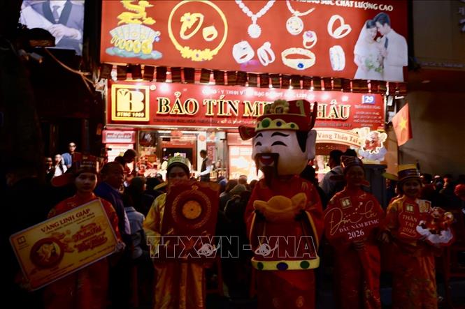 Người dân đội mưa chờ mua vàng ở cửa hàng Bảo Tín Minh Châu (Trần Nhân Tông, Hà Nội). Ảnh: Trần Việt - TTXVN 