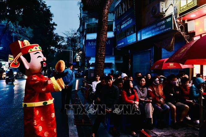 Người dân đội mưa chờ mua vàng ở cửa hàng Bảo Tín Minh Châu (Trần Nhân Tông, Hà Nội) từ rất sớm. Ảnh: Trần Việt - TTXVN 