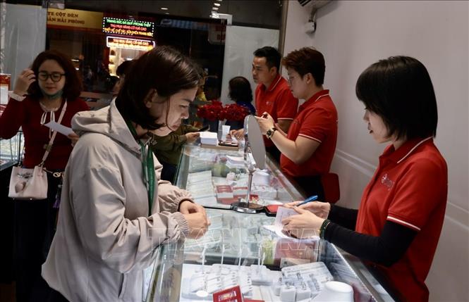 Người dân mua vàng Ngày vía Thần Tài tại cửa hàng Doji. Ảnh: Trần Việt - TTXVN 