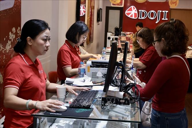 Người dân mua vàng Ngày vía Thần Tài tại cửa hàng Doji. Ảnh: Trần Việt - TTXVN 