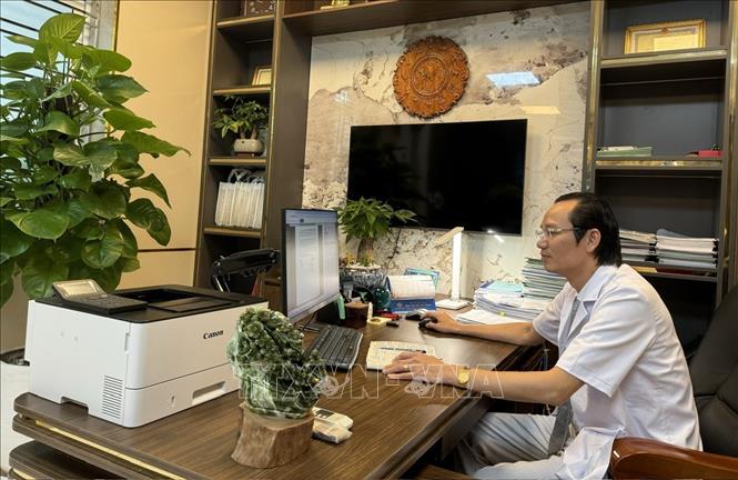 Bác sĩ chuyên khoa II Nguyễn Đức Quân, Giám đốc Bệnh viện Mắt Hải Phòng, kiểm tra nhật ký làm việc trong ngày của các khoa, phòng. Ảnh: Minh Huệ-TTXVN