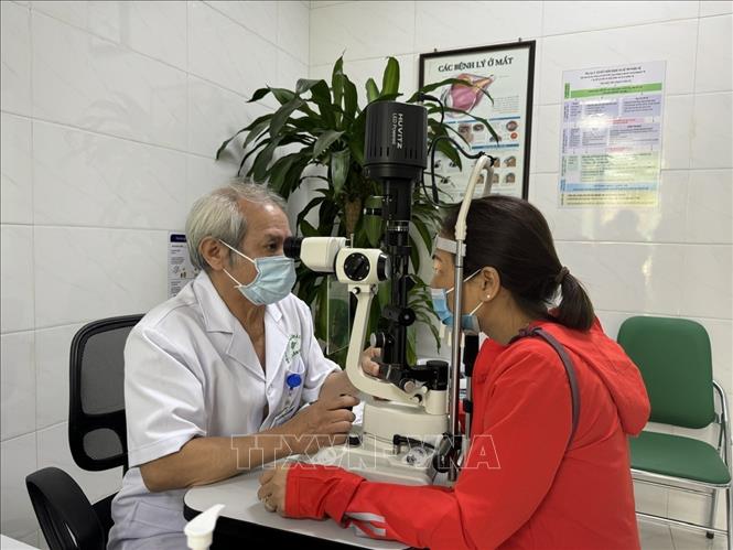 Chuyên gia đầu ngành thực hiện khám mắt cho bệnh nhân. Ảnh: Minh Huệ-TTXVN.