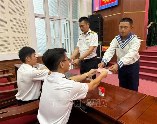 Cử tri tại Bộ Tư lệnh Vùng 2 Hải quân nhận phiếu chứng nhận bỏ phiếu bầu cử. Ảnh: TTXVN	 